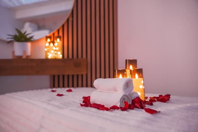 Spa towels and candles against warm wooden wall